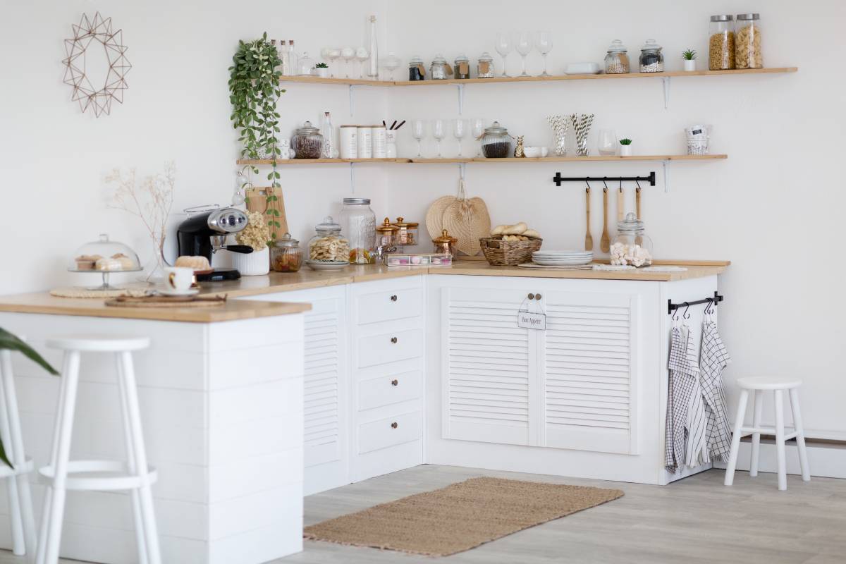 Cozy white empty kitchen, modern interior without stove and sink made in rural style, comfortable warm light kitchen full of utensils, furniture, coffee machine. Home interiors concept