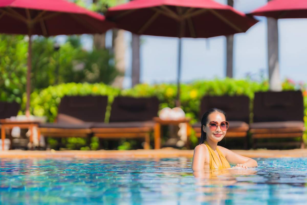 Portrait beautiful young asian woman leisure relax smile and happy around swimming pool in hotel resort for holiday vacation trip