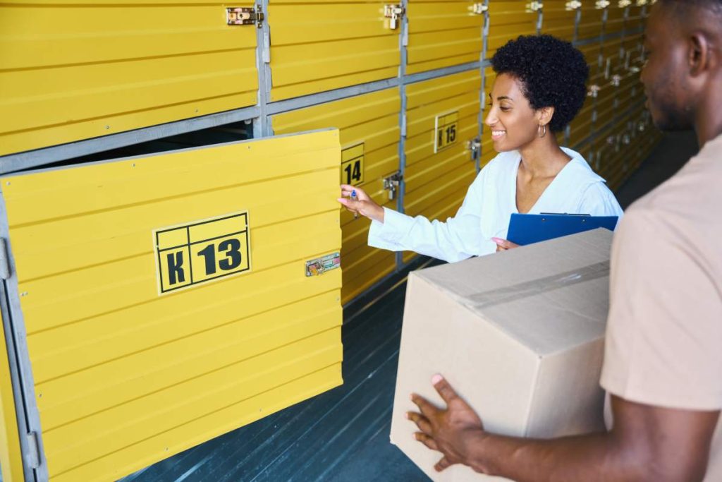 Woman manager opens a storage box for a client, and a man has a cardboard box