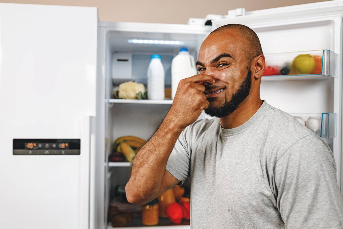 African american man closing nose because of bad smell from his fridge